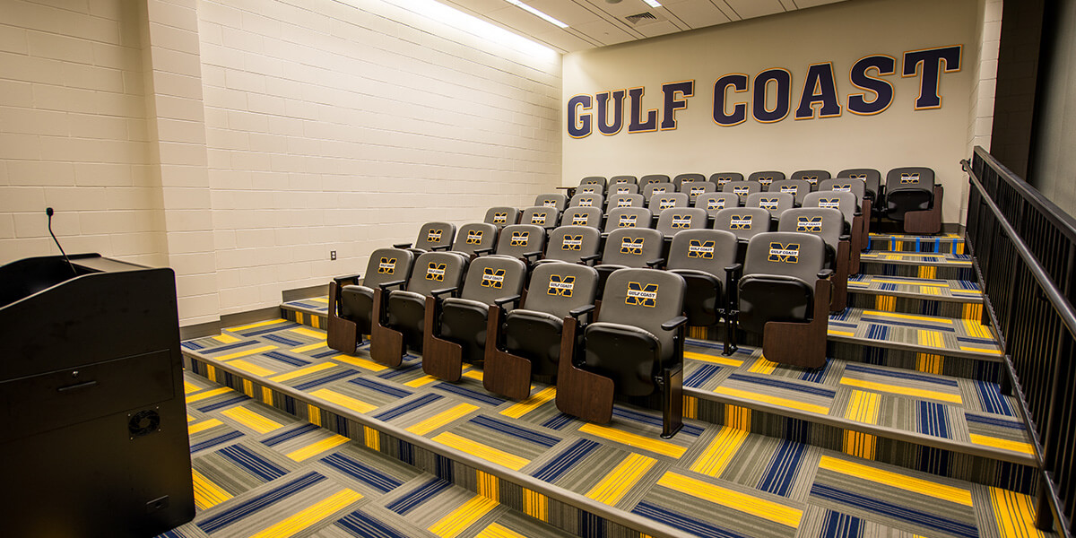 Theater style seats face podium in a classroom.