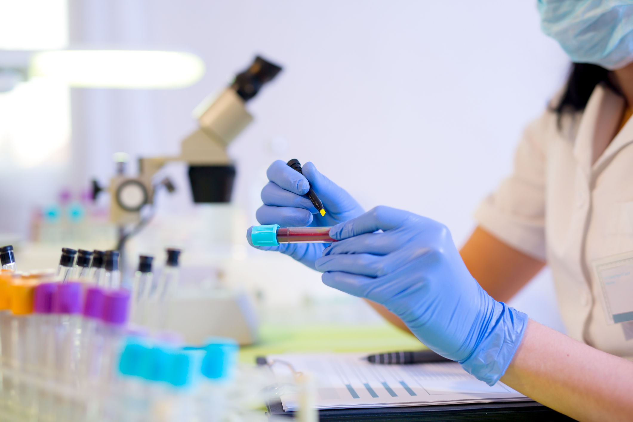 Woman working in a laboratory. She writes with a felt pen.