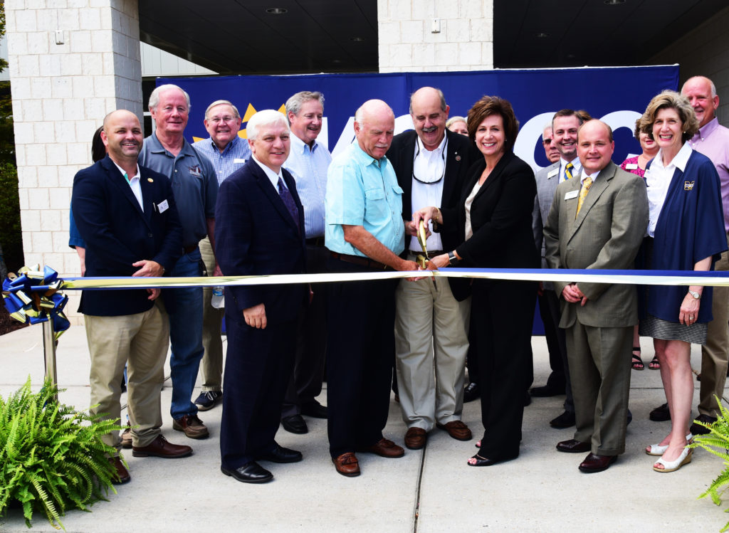 MGCCC president Dr. Mary S. Graham and others cutting the ribbon at the West Harrison County Center with oversized scissors