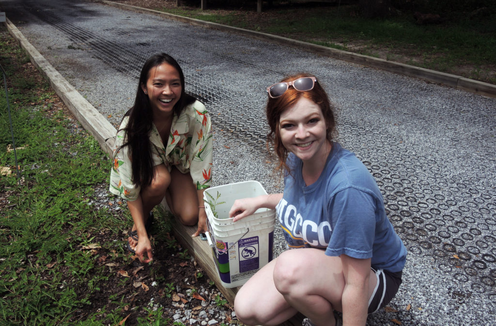 MGCCC students Meghan Nguyen and Katlyn Scott weeding an area at the Pascagoula River Audubon Center in Moss Point