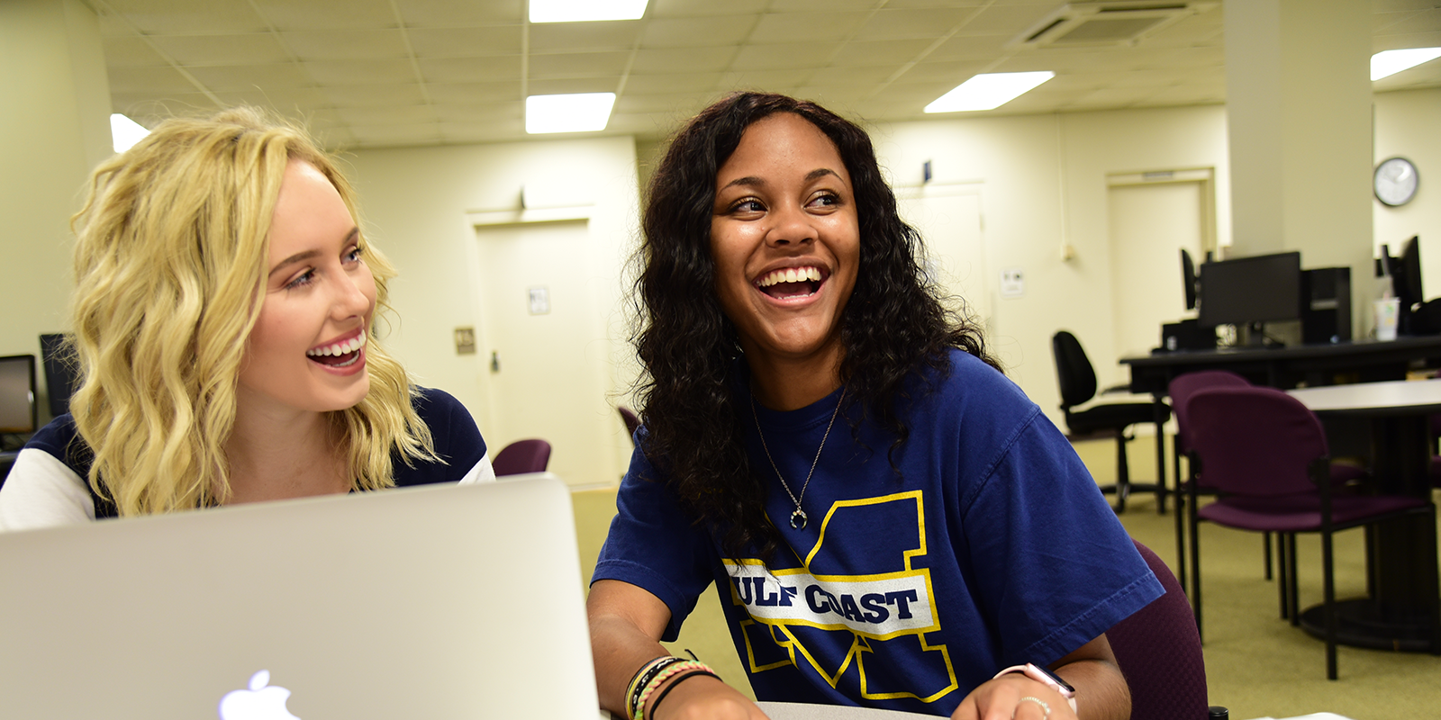 Helping female student register for classes at a laptop