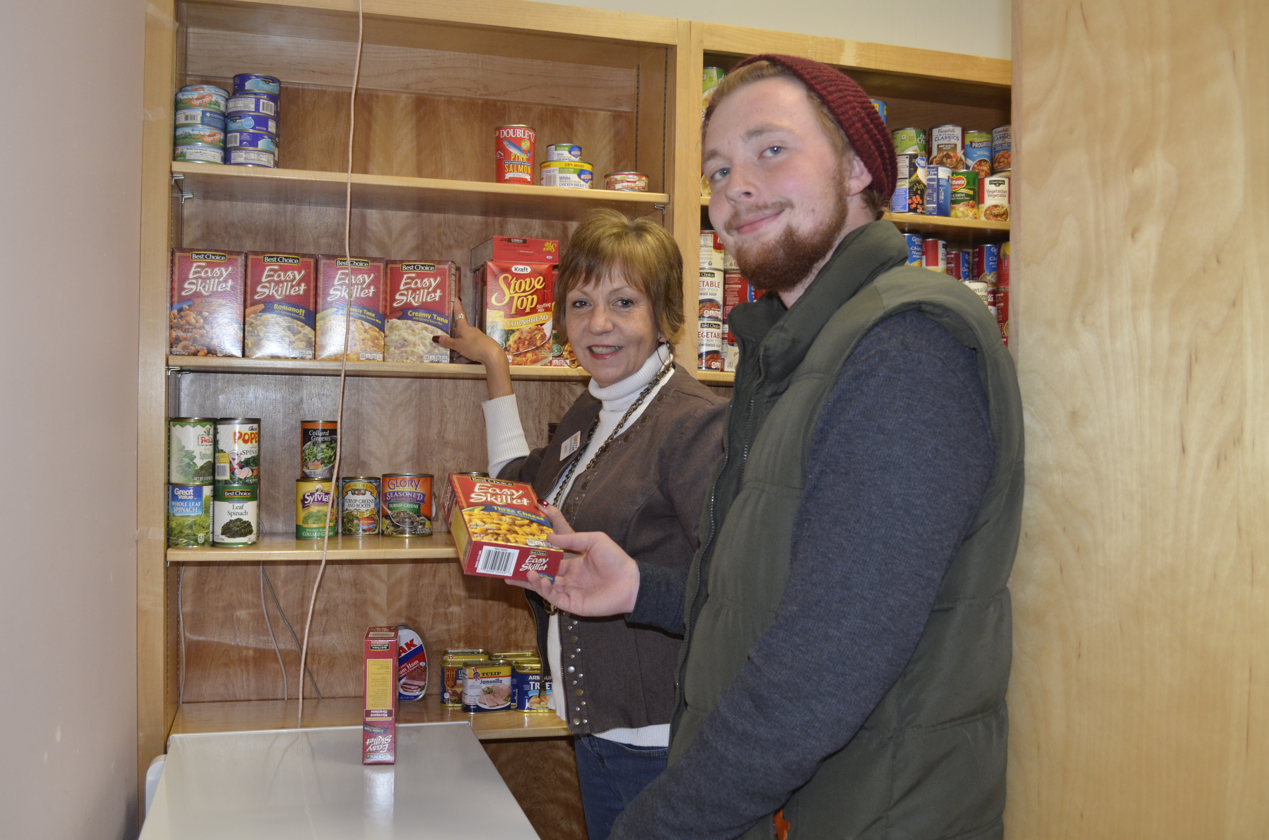 Carin Platt and Jake Franks putting items on the shelf in the food pantry