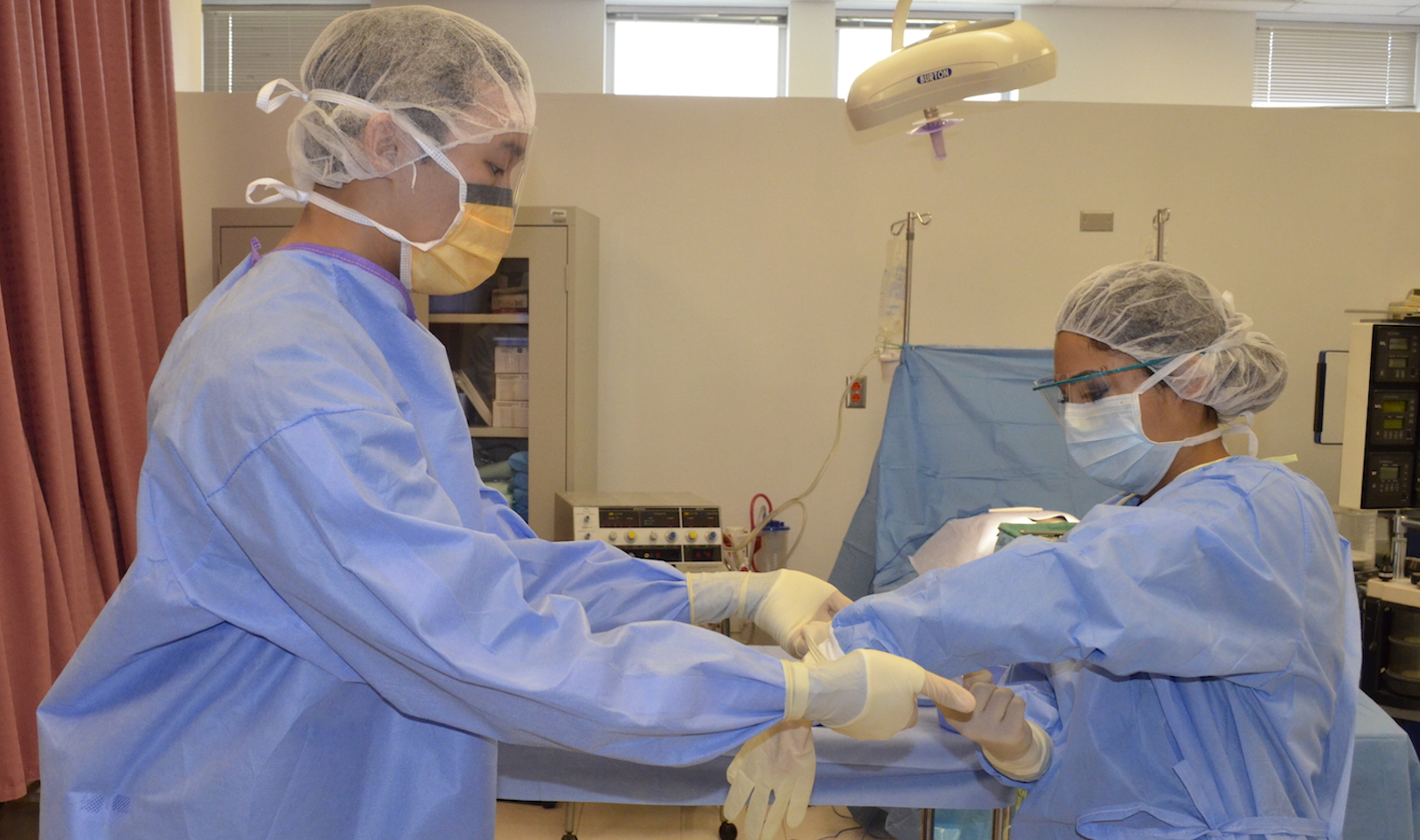 Surgical Technology students putting on gloves