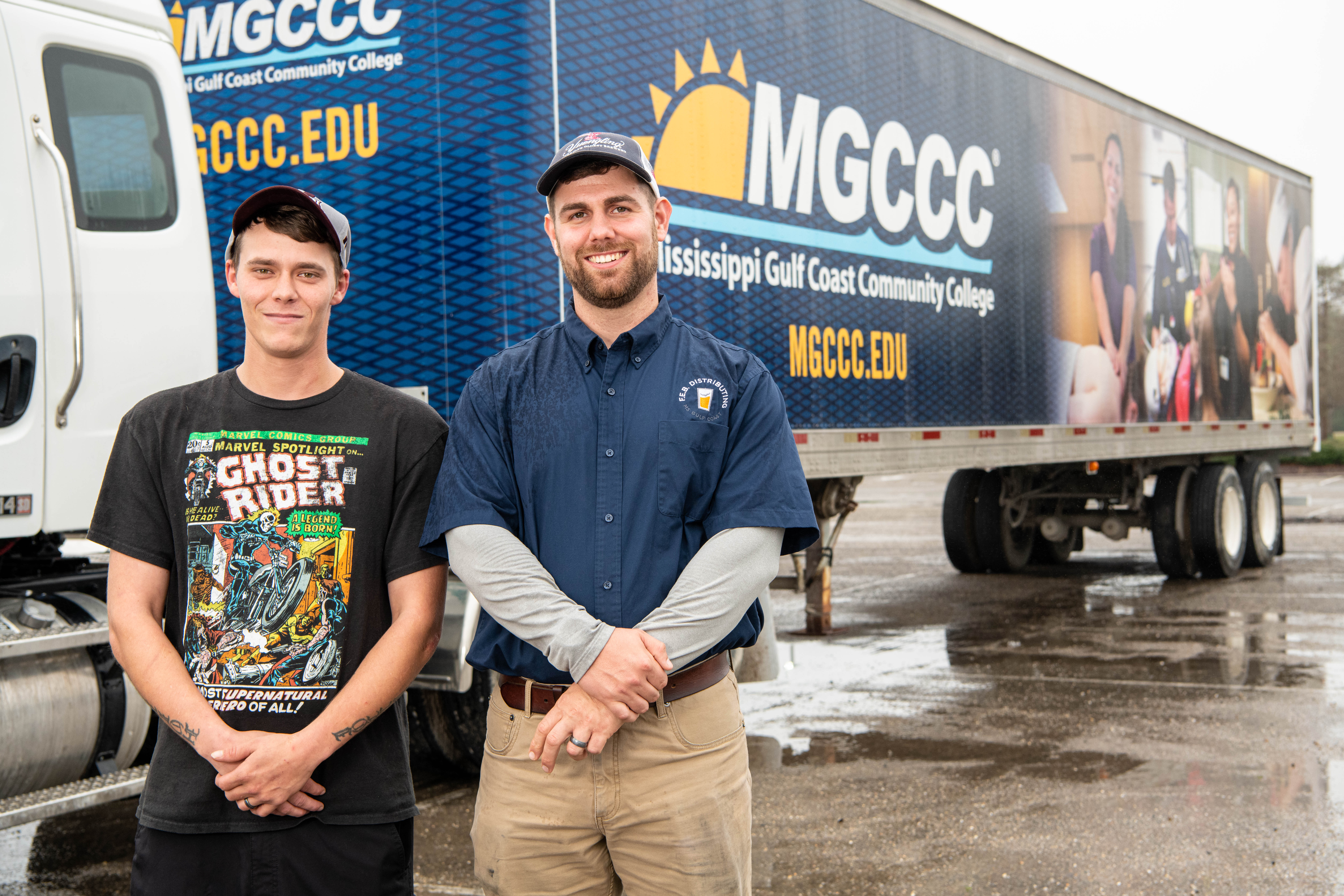 Photo of the two apprentices in front of MGCCC's 18-wheel truck used in the CDL program