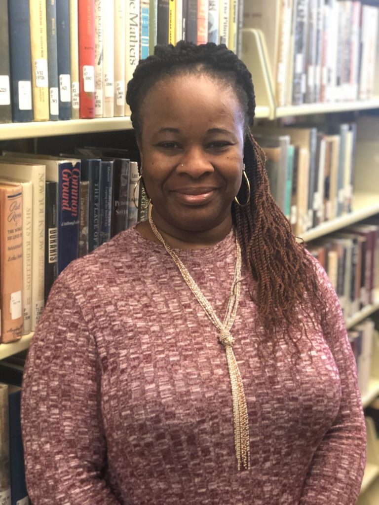 Valerie Bonner standing in front of books in the library
