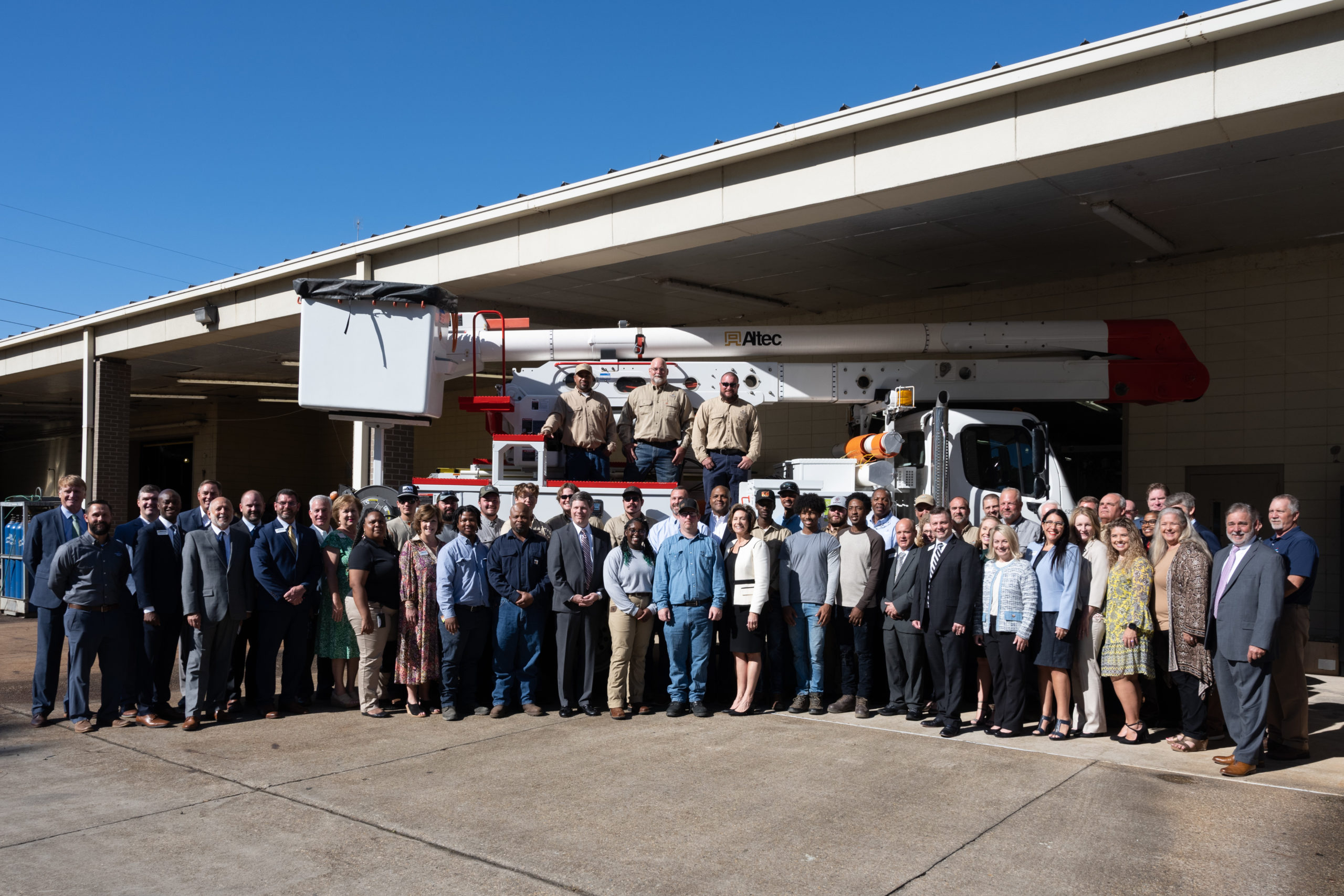 Mississippi Power and MGCCC employees along with the 15 students in the Electric Lineworker Training program with one of the trucks that Mississippi Power is donating to the MGCCC Foundation