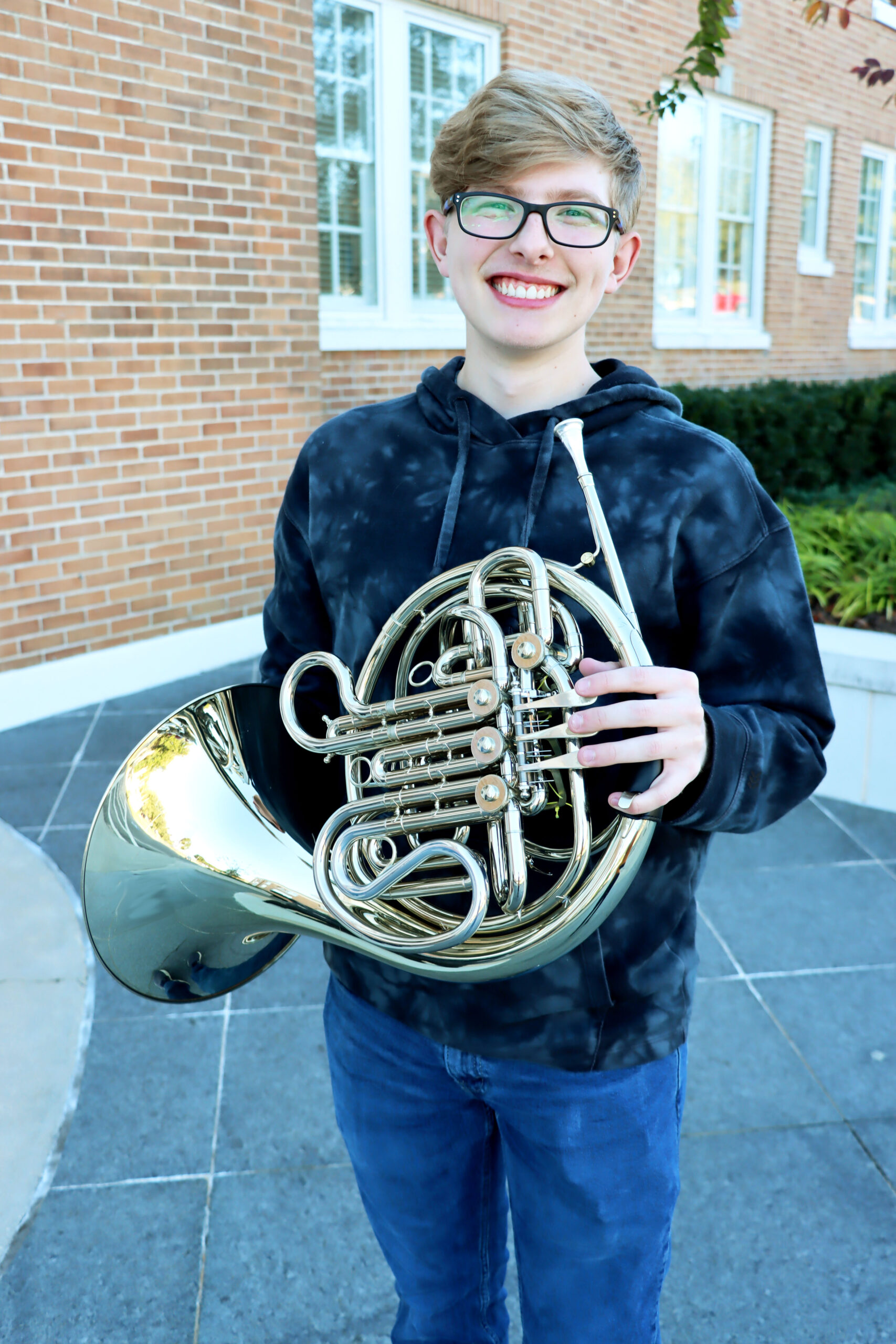 Student Ryan Lee holding his French horn