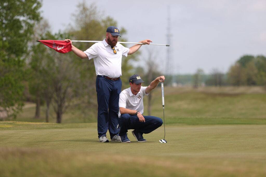 Coach Brad Thornton helping Will Burnham on the golf links.