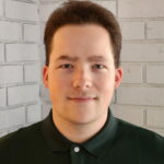 Portrait of Aiden Graves standing in front of a brick wall