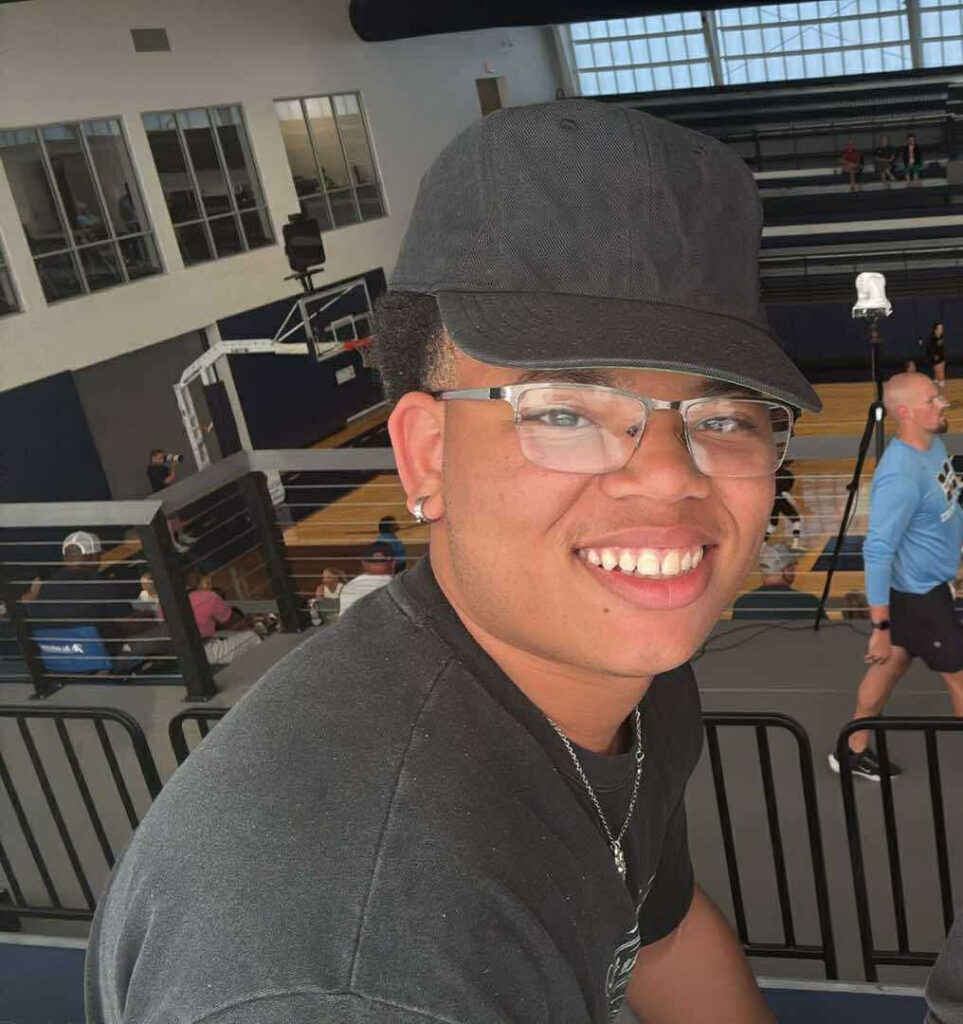 Tavon Reed portrait of him sitting at the Dantzler Center watching basketball.