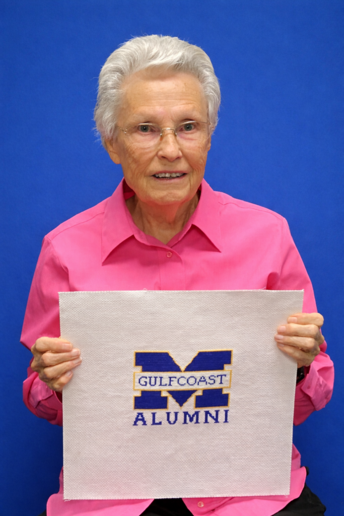 Edith Patton Rutherford at Jackson Hall holding up a piece of her cross stitch.