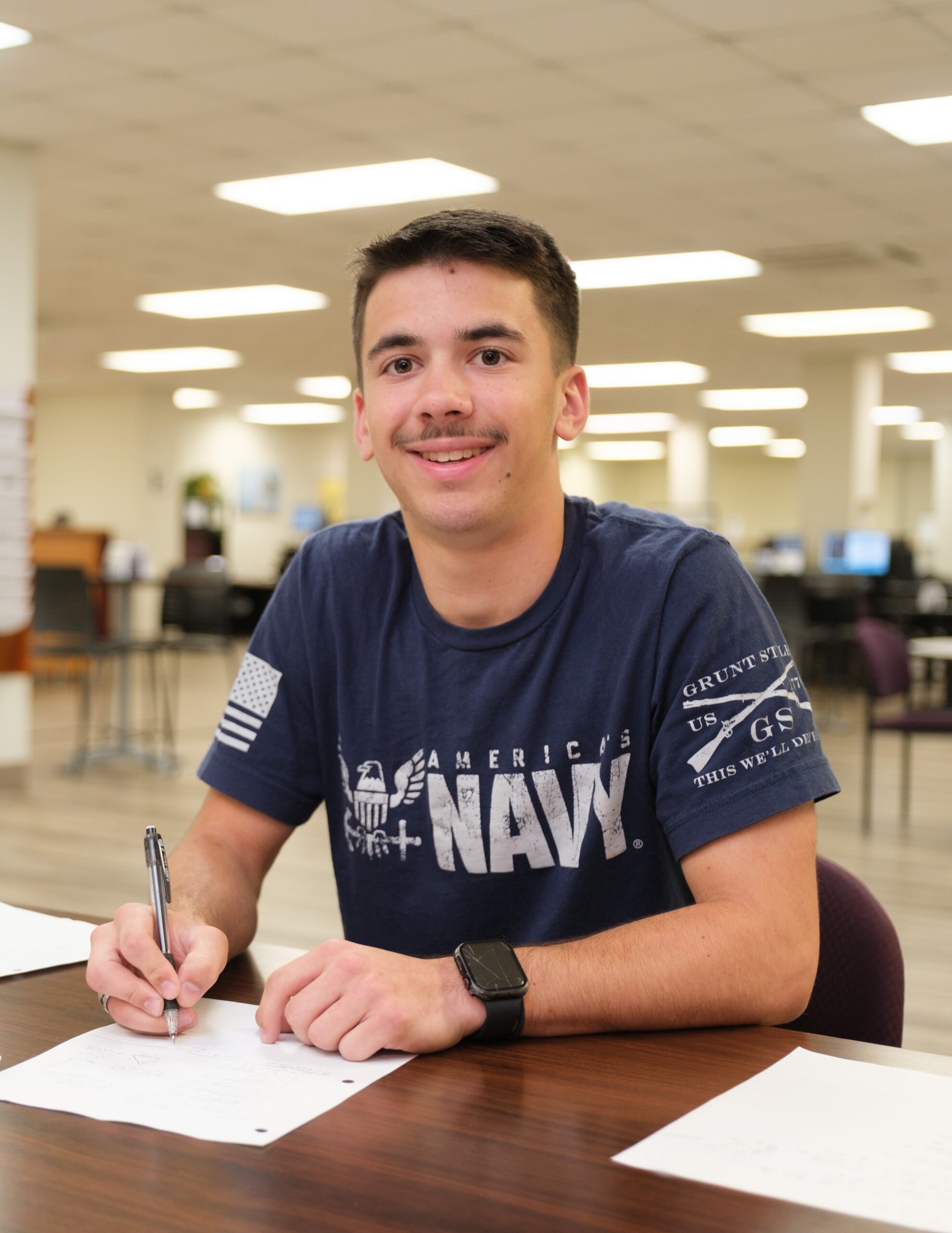 Jon Hayden working in the LRC at the JC Campus. Student at desk with blue navy shirt on.